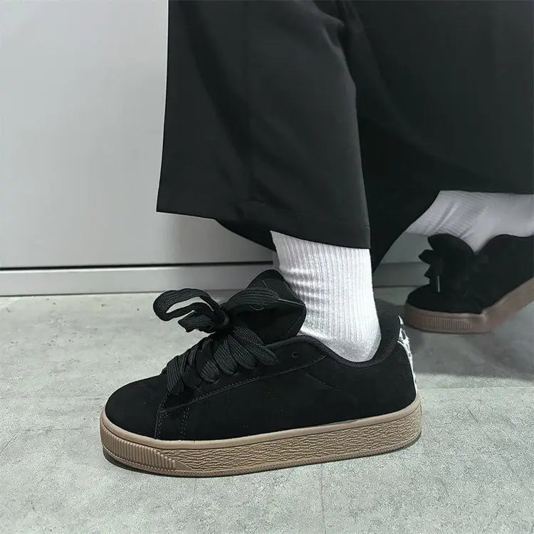 "Vue de profil des baskets streetwear chic noires femme semelle épaisse stable"