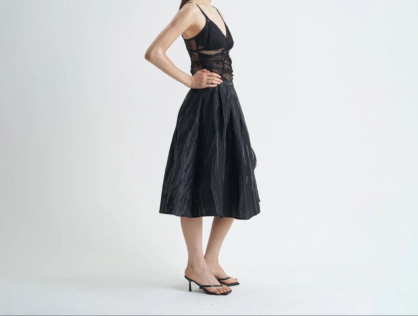 Jupe noire chic mi-longue en coton avec motifs en relief 3D, coupe évasée pour une silhouette élégante et confortable.
