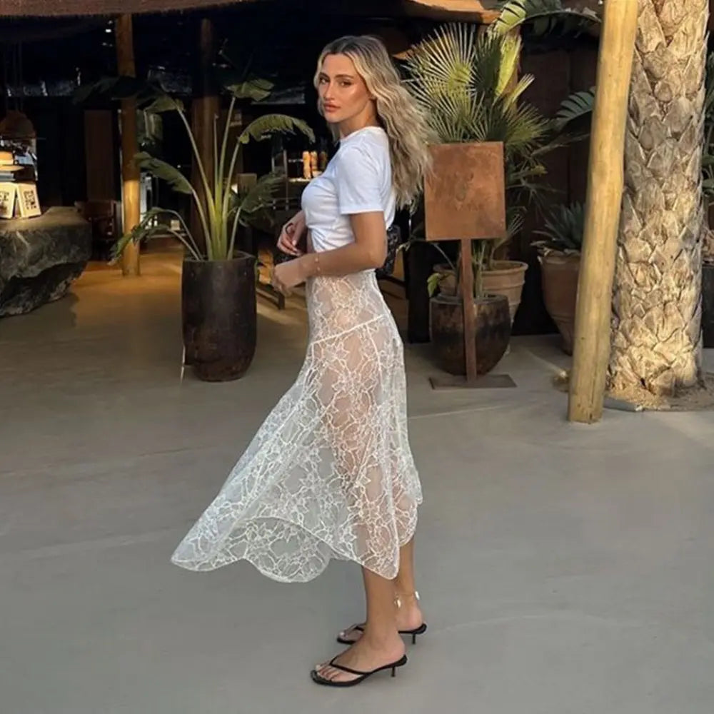 Jupe en dentelle transparente blanche, coupe basse, finitions ajourées raffinées, look romantique et audacieux