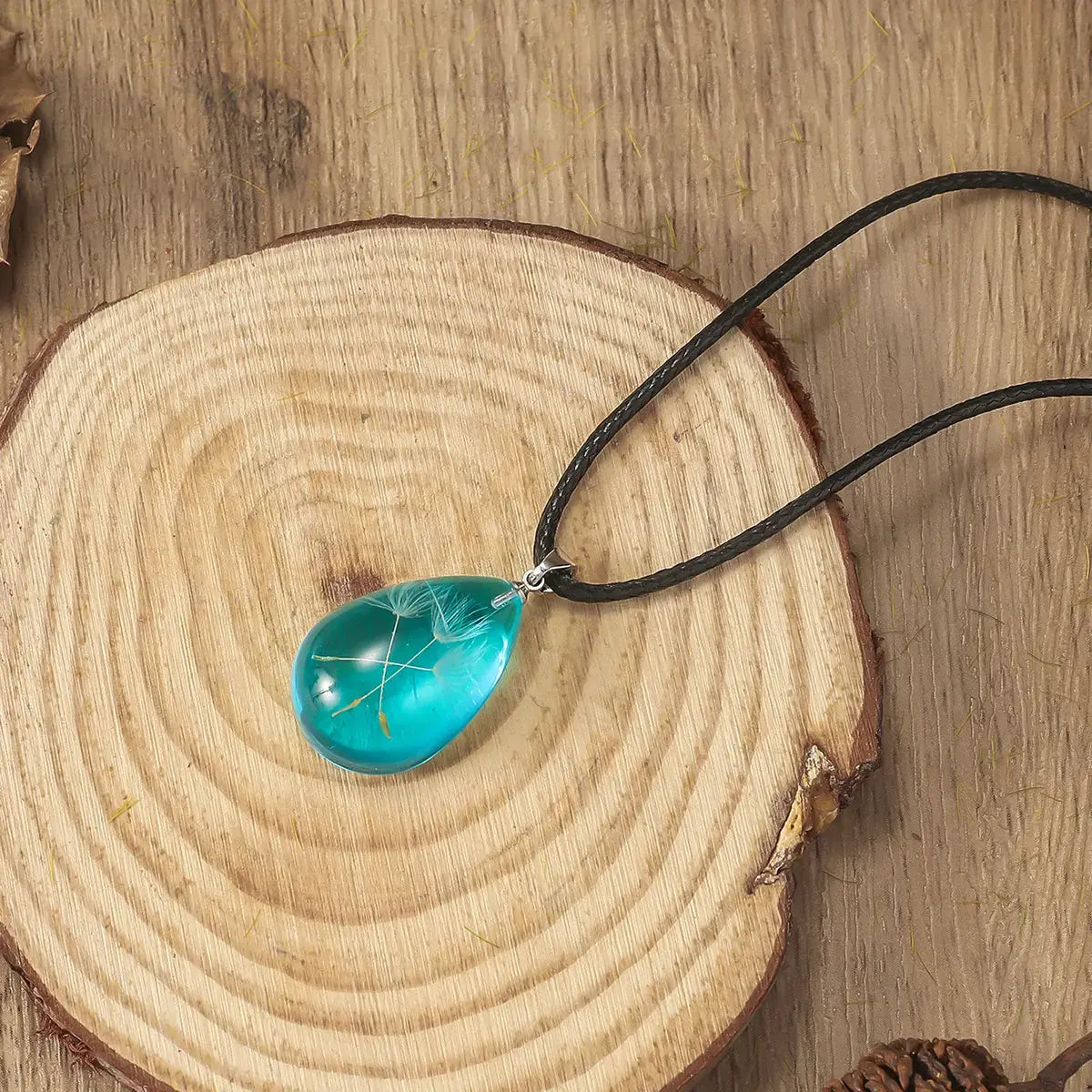 Boucles d’oreilles goutte avec fleur suspendue en résine transparente, design poétique et artisanal.