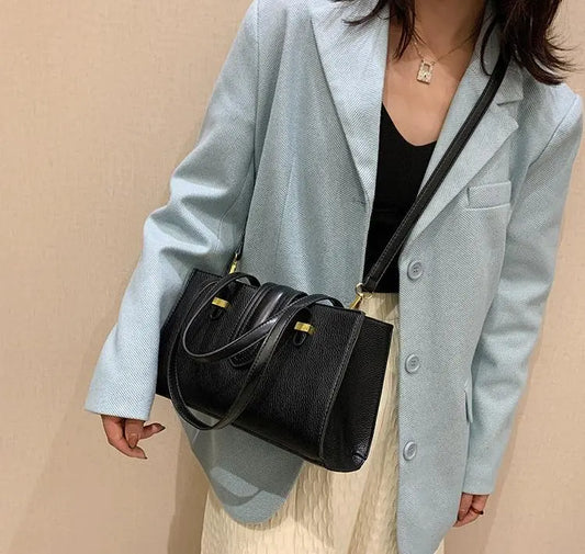 Sac urbain en cuir végan noir, vue de face, design simple et élégant.