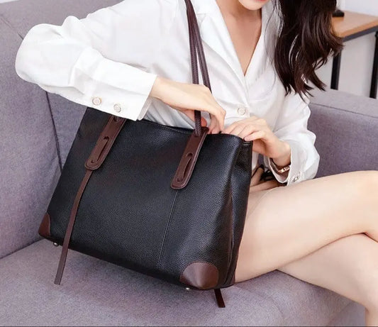 Sac en cuir marron porté à la main, élégant et pratique pour le quotidien.