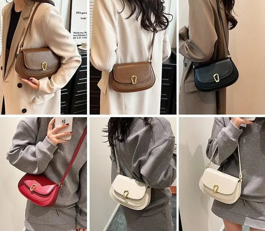 Sac à main noir porté à l’épaule avec double bretelles, style urbain chic.