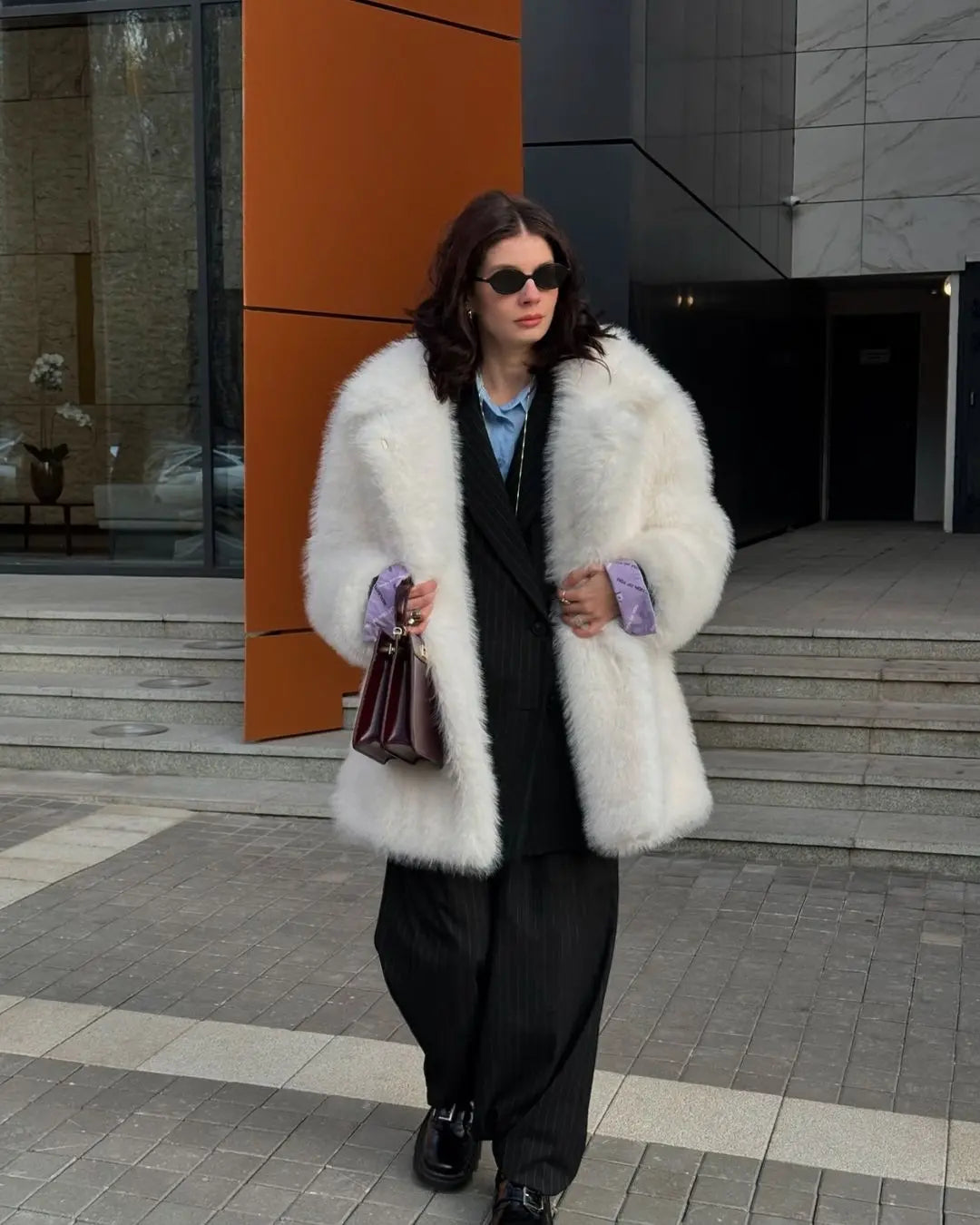 Veste blanche en fourrure synthétique, associée à bottines hautes et sac structuré