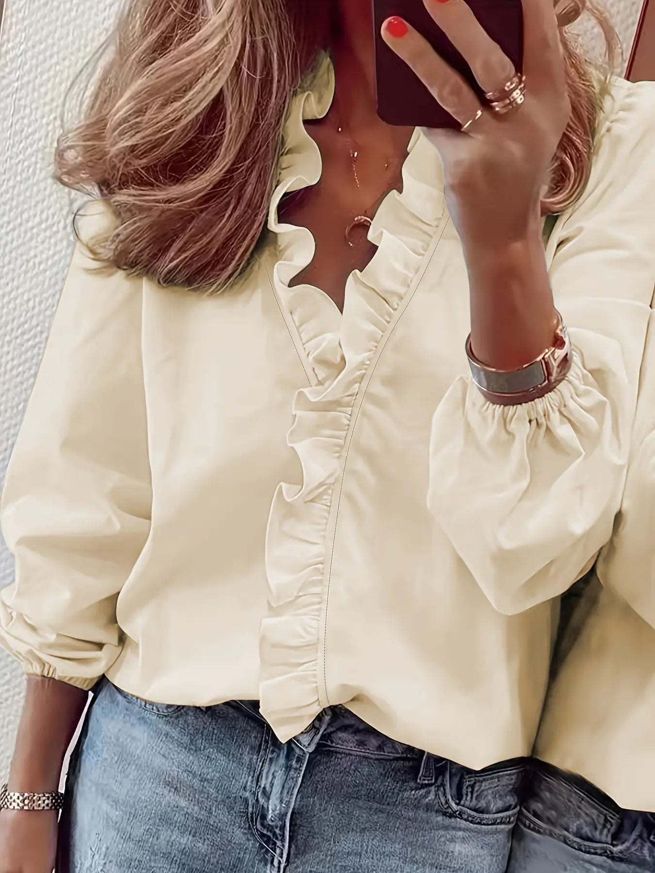 Blouse féminine fluide et légère, manches longues à poignets élastiqués, volants décoratifs sur le col V et le buste, parfaite pour un look féminin et structuré.