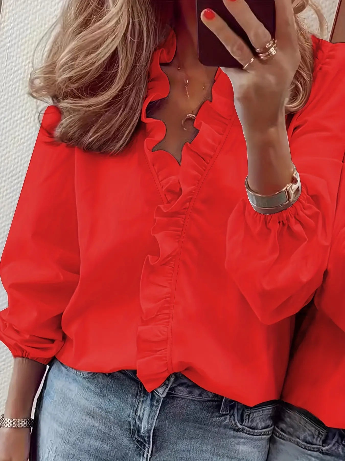 Blouse fluide femme, manches longues à poignets élastiqués, volants élégants sur le col V et le buste, look féminin et tendance, disponible en S à 2XL.

