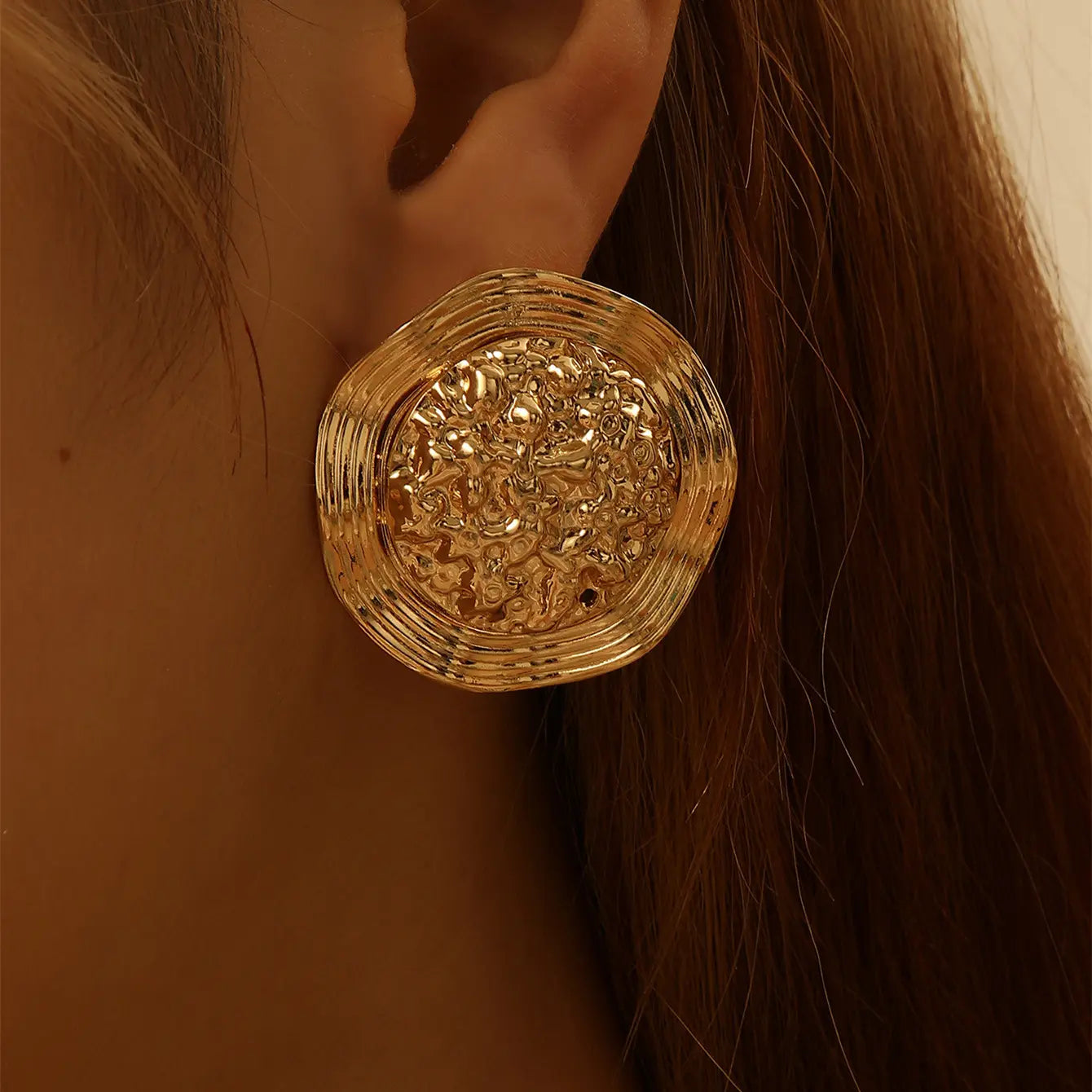 Boucles d’oreilles géométriques avec texture fine, reflet lumineux et raffiné.