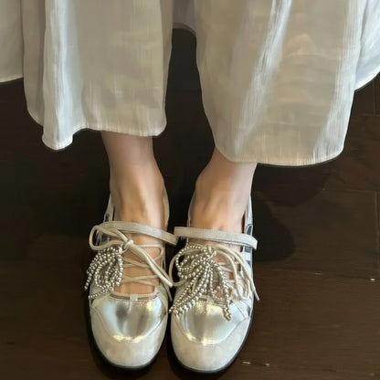Paire de chaussures plates métallisées dorées avec lacets décoratifs