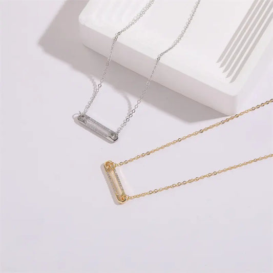 Collier minimaliste avec pendentif en forme d’épingle orné de zircons scintillants.