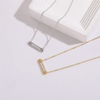 Collier minimaliste avec pendentif en forme d’épingle orné de zircons scintillants.
