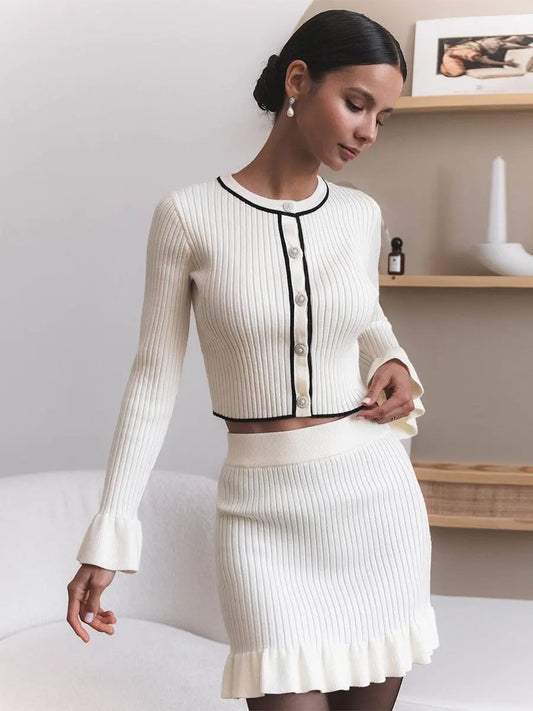 Ensemble chic femme blanc, gilet à boutons avec manches longues à volants et jupe courte assortie, look féminin et tendance.