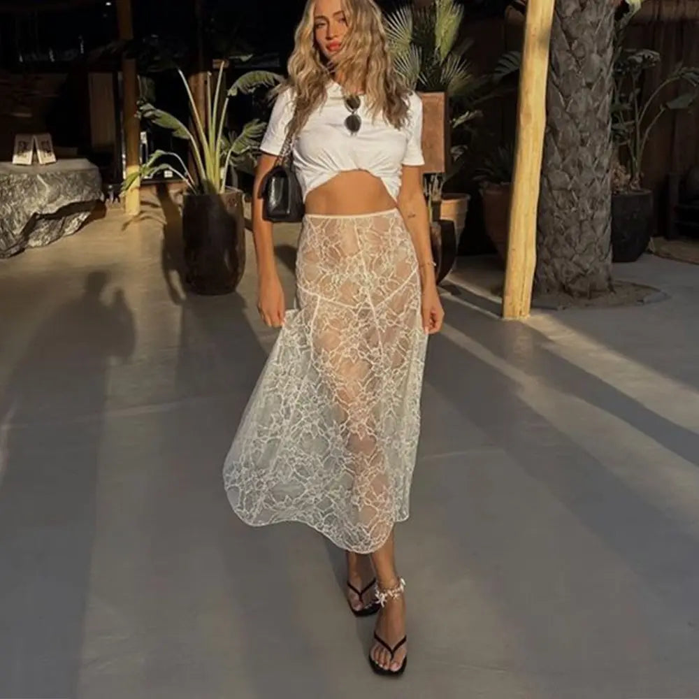 Jupe blanche en dentelle transparente, coupe basse, finitions ajourées, style romantique et élégant
