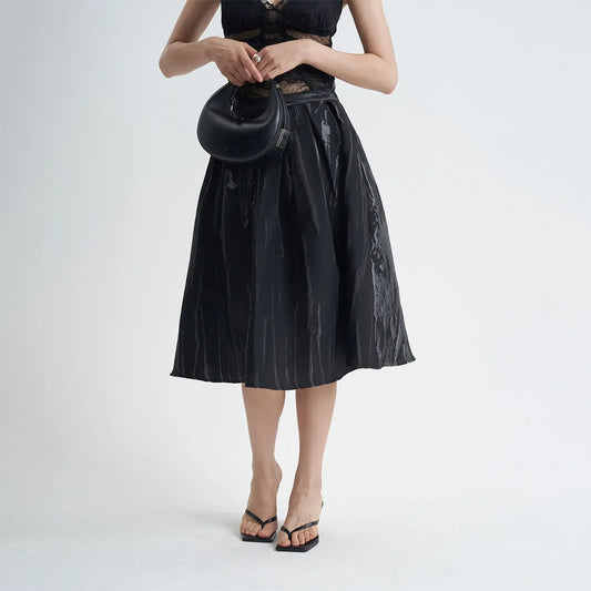 Jupe mi-longue noire chic en coton avec motifs 3D, coupe évasée confortable, idéale pour un look élégant et moderne.
