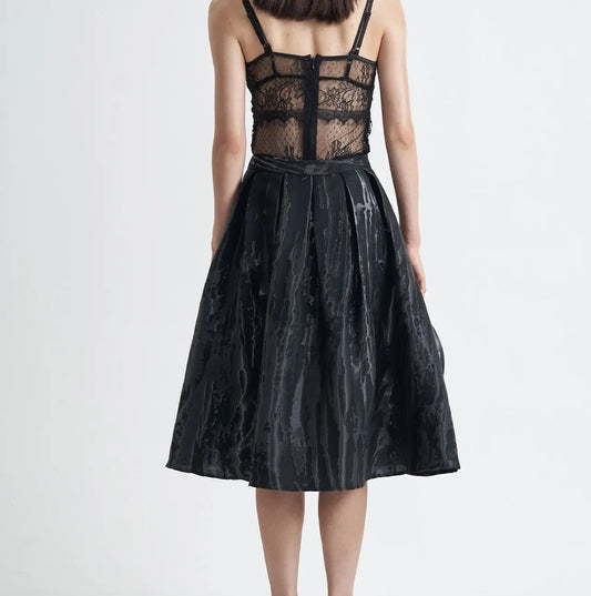 Jupe moderne noire mi-longue à motif 3D, style sobre et raffiné, idéale pour un look élégant et féminin.
