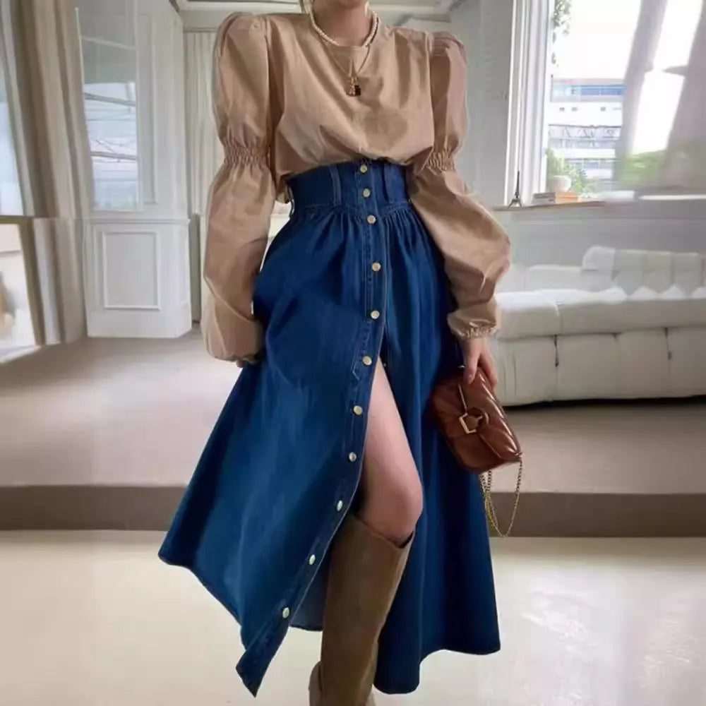 Jupe en denim bleu clair mi-longue avec fente avant et coupe évasée.