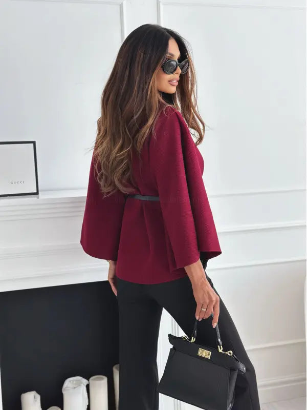 Vue de profil du manteau cape femme bordeaux porté avec un pantalon noir SecretBombe