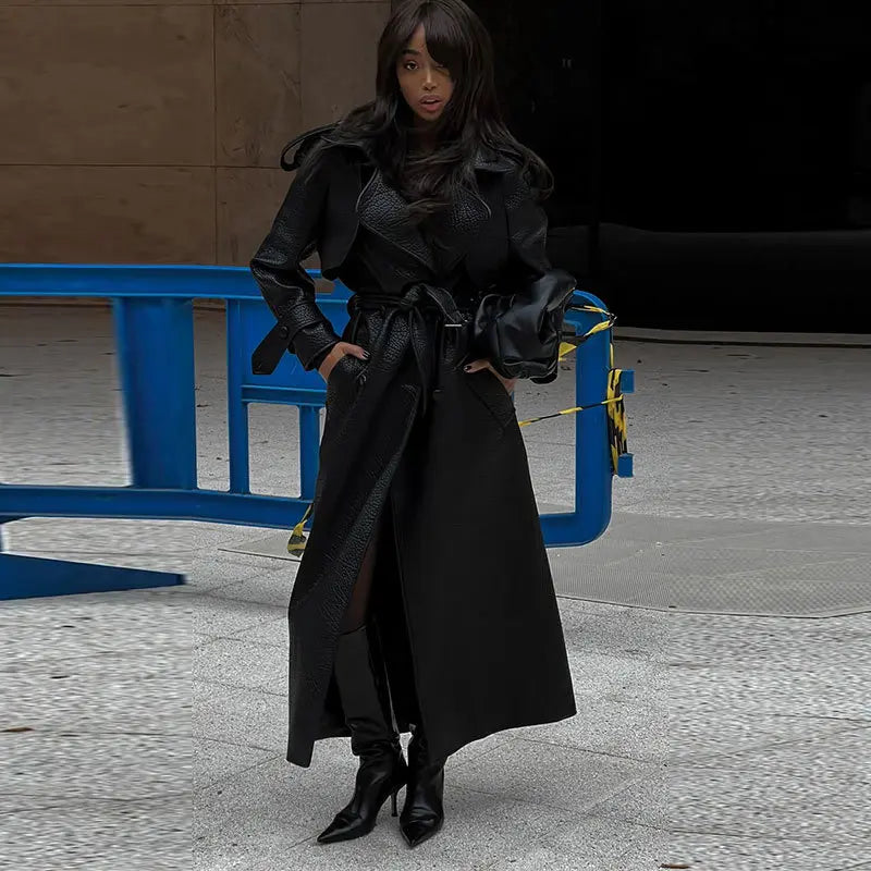 Manteau en cuir végan  noir pour femme avec ceinture à nouer, style chic et moderne.