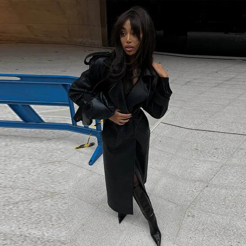 Manteau en cuir végan  noir pour femme avec ceinture à nouer, style chic et moderne.