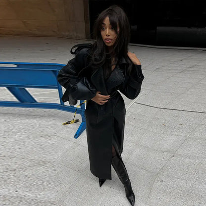 Manteau en cuir végan  noir pour femme avec ceinture à nouer, style chic et moderne.