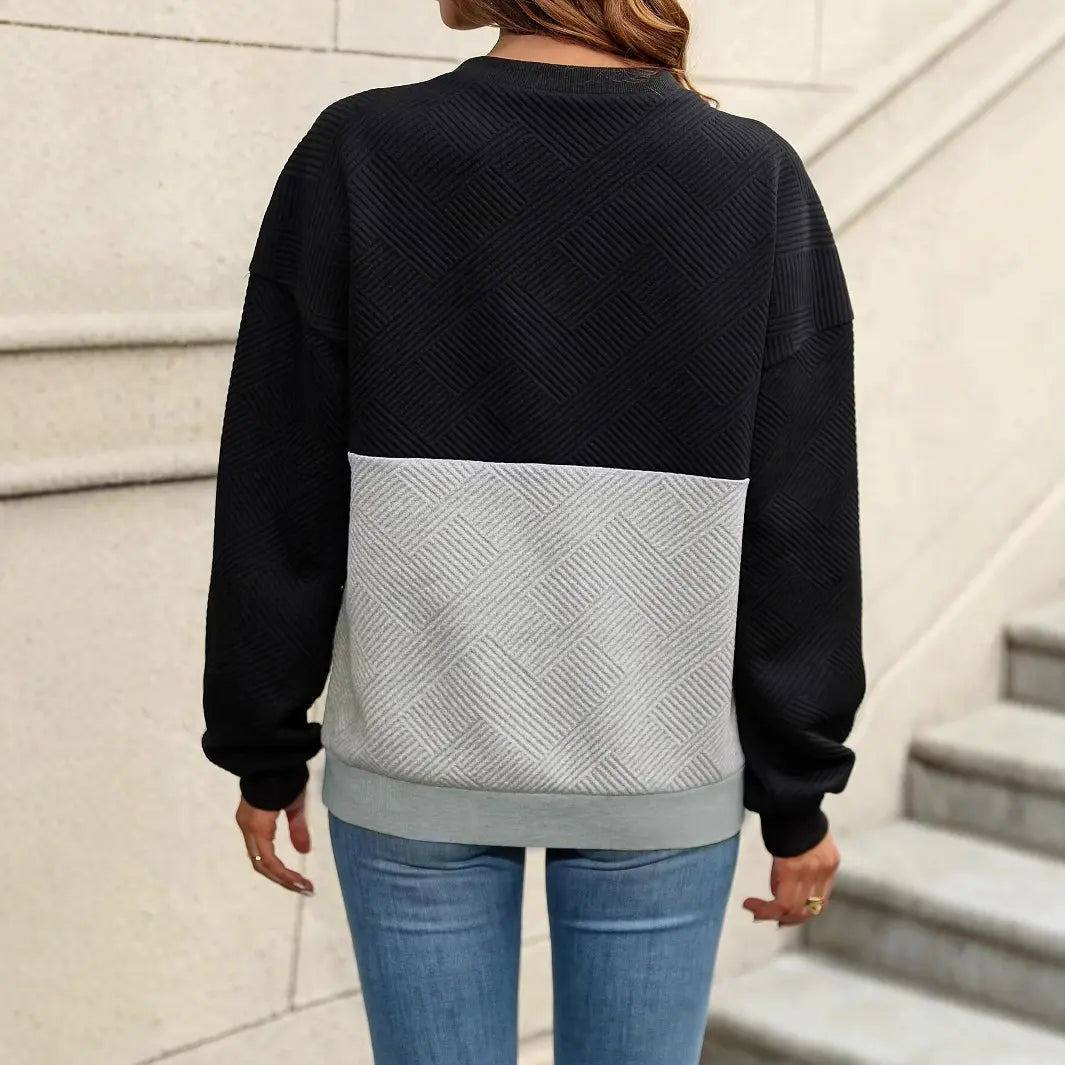 Pull femme noir élégant avec col en V et lanières croisées, style décontracté chic, empiècement gris texturé, coupe régulière manches longues