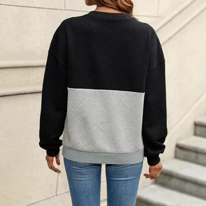 Pull femme noir élégant avec col en V et lanières croisées, style décontracté chic, empiècement gris texturé, coupe régulière manches longues