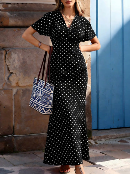 Robe noire longue à pois avec manches papillon et coupe fluide