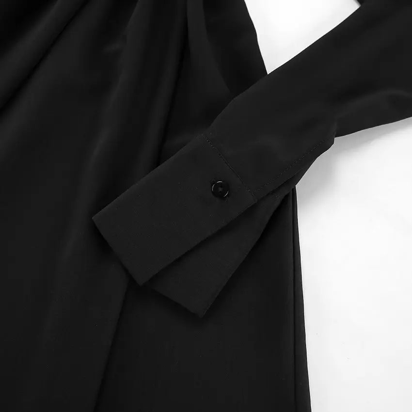 Gros plan sur les manches bouffantes boutonnées d’une robe trapèze noire