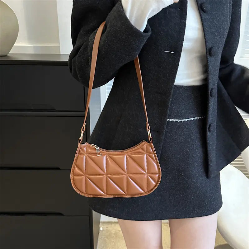 Sac à main marron en cuir végan porté à la main, look chic et moderne.