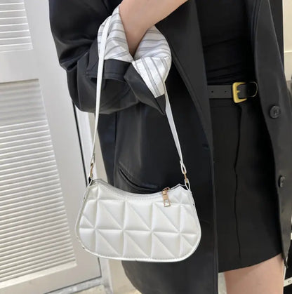 Sac bandoulière blanc porté à l’épaule, design élégant et pratique.