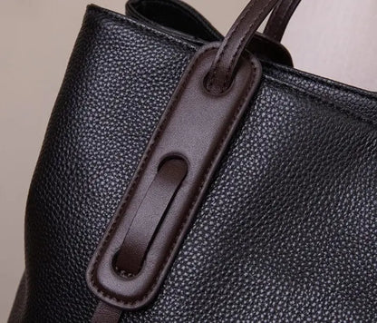 Sac en cuir noir porté à l’épaule, style chic et intemporel.