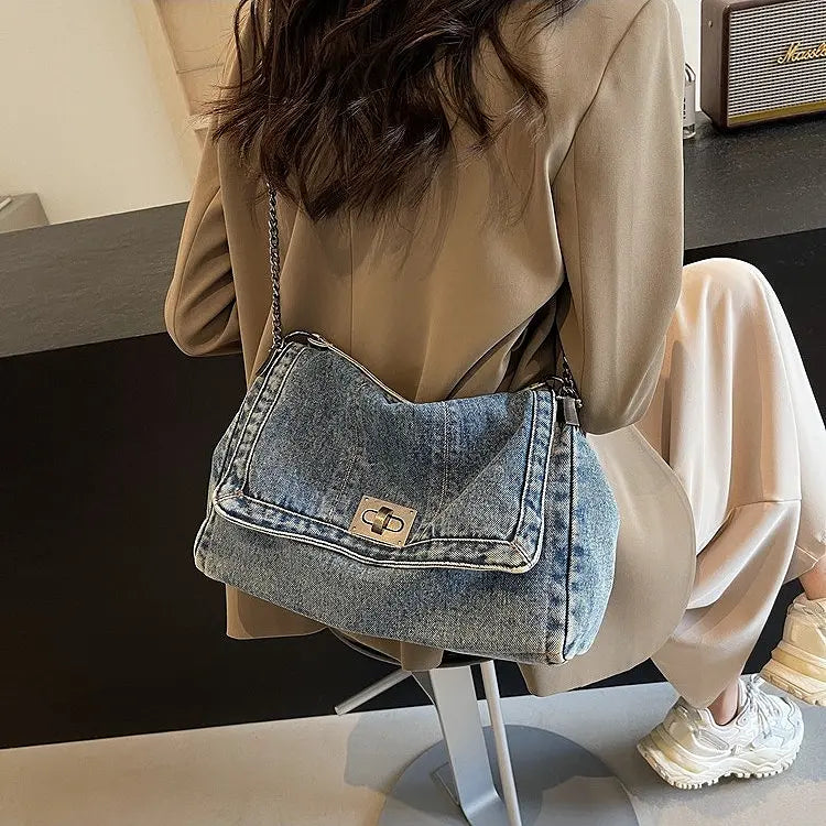Sac en denim bleu délavé au design moderne avec poche extérieure.