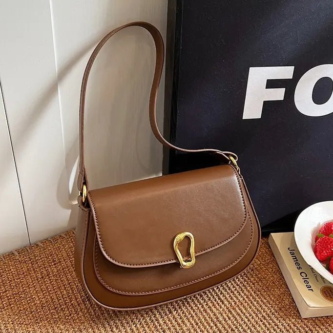 : Sac à main urbain en cuir végan porté avec une tenue élégante et casual.