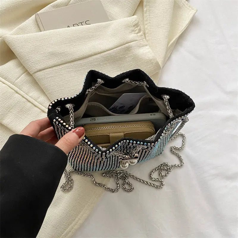 Gros plan sur les détails décoratifs en diamants du sac seau noir.