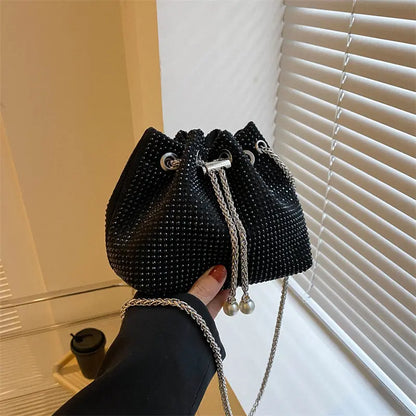 Sac seau noir porté à l’épaule avec bandoulière élégante.