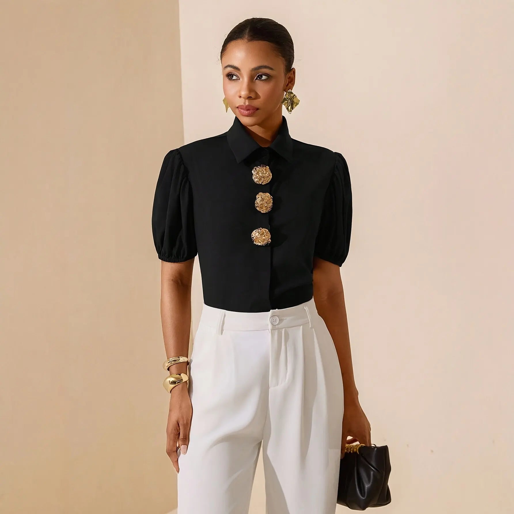 Chemise noire chic pour femme portée avec un pantalon blanc SecretBombe