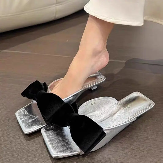 Mules femme tendance 2026 avec grand nœud disponibles en noir, blanc et argent - SecretBombe