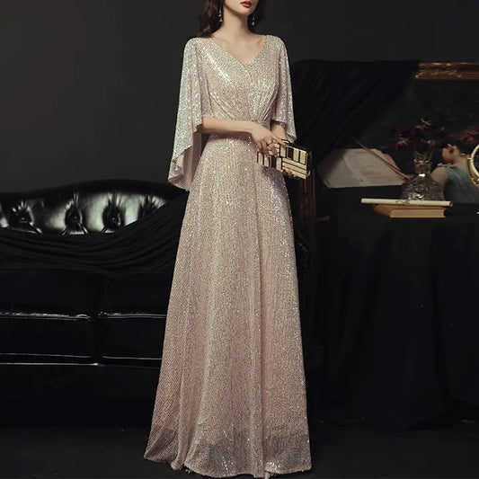 Robe de soirée longue SecretBombe portée par mannequin, col V profond et manches cape élégantes