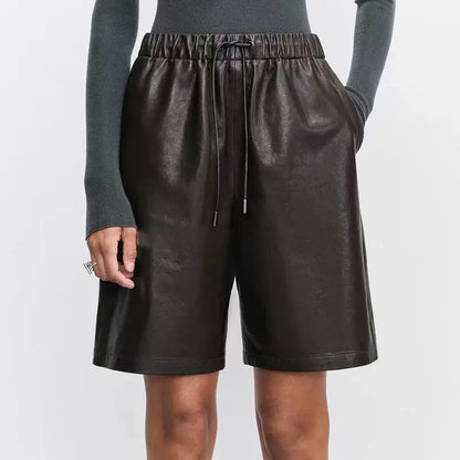 Look féminin chic avec short en cuir noir taille haute et coupe droite