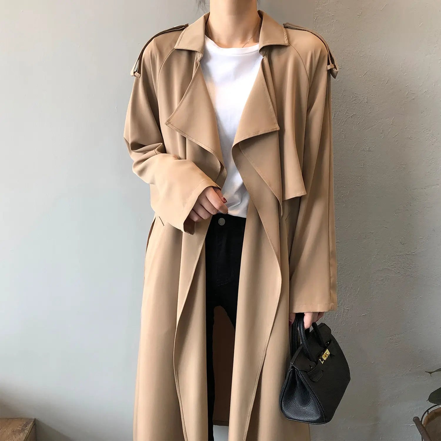 « Trench féminin coupe droite, manches longues classiques, épaisseur moyenne, coloris taupe ou noir, modèle élégant et confortable pour toutes les occasions. »